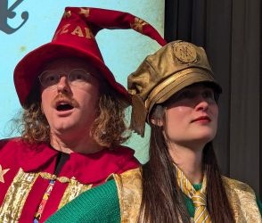 Ben McKenzie and Elizabeth Flux, dressed as Rincewind and Moist Von Lipwig, as per the Pratchat Podcast logo